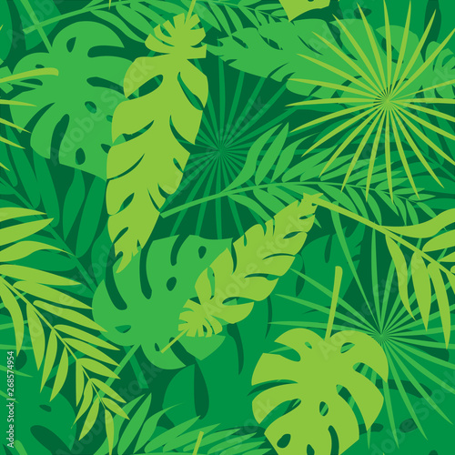 Seamless pattern made with green and yellow silhouettes of tropical leaves on dark green background. Tropic folage texture.Vector flat illustration