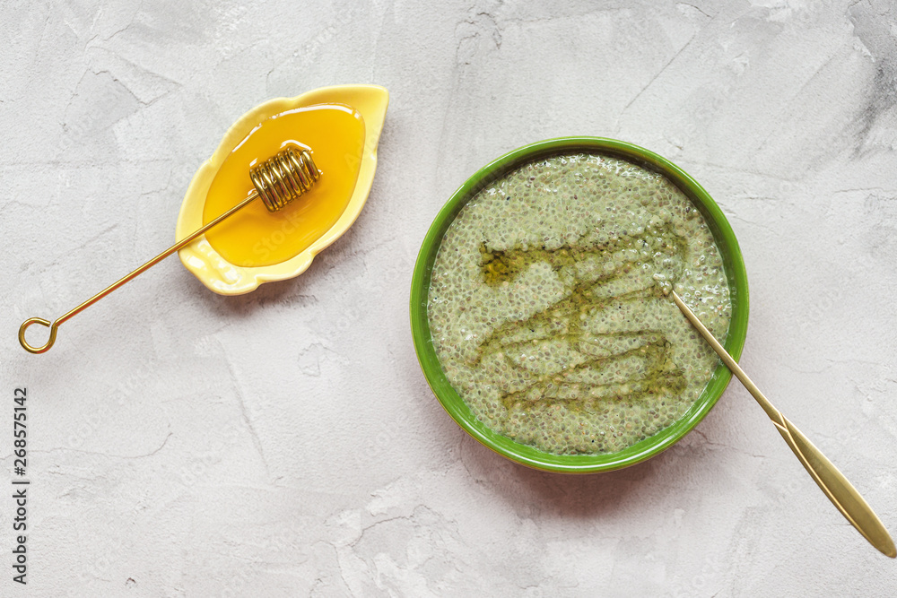 Matcha green tea chia seed pudding bowl with honey. Superfood and vegan concept. Matcha green tea chia seed pudding bowl with honey. Superfood and vegan concept.