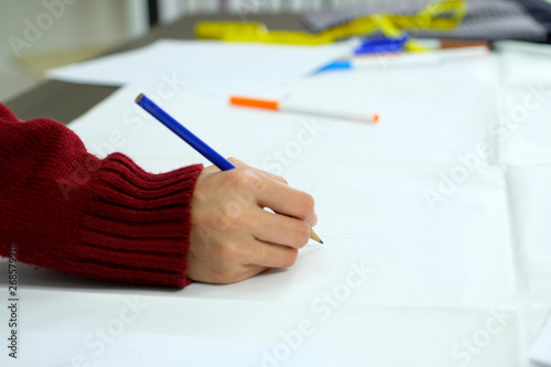 Woman hand holding pencil drawing and skectching creative design art ideas on white paper at working desk