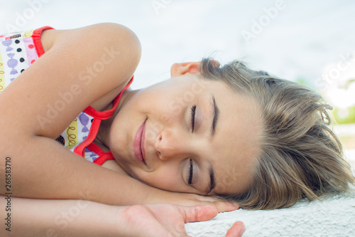 Close little girl lying down thinking with strong  penetrating look