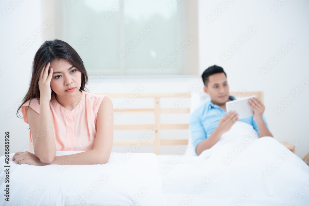 Social Ignore, Upset funny of wife on the bed while husband watching social online in a tablet. It's Smartphone face or Nomophobia Syndrome, Problem of relationship concept Social Ignore, Upset funny of wife on the bed while husband watching social online in a tablet. It's Smartphone face or Nomophobia Syndrome, Problem of relationship concept