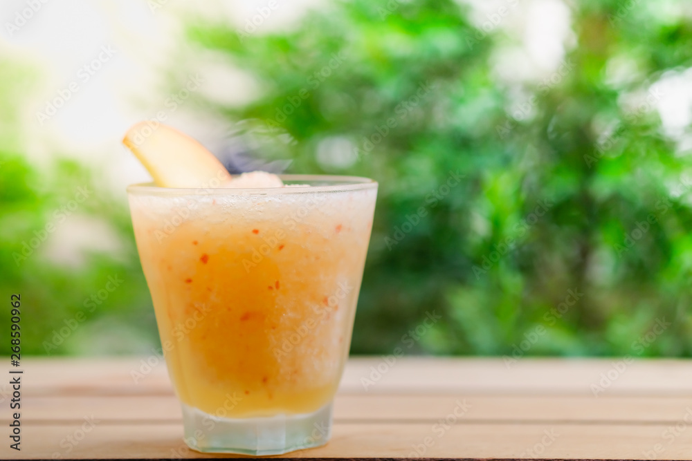 Close up of glass of iced apple juice frappe frozen with green nature background. Close up of glass of iced apple juice frappe frozen with green nature background.