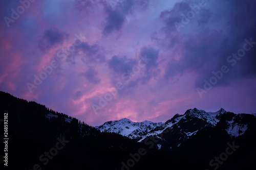 Amazing mountain landscape with colorful vivid sunset on the cloudy sky, natural outdoor travel background. Beauty world
