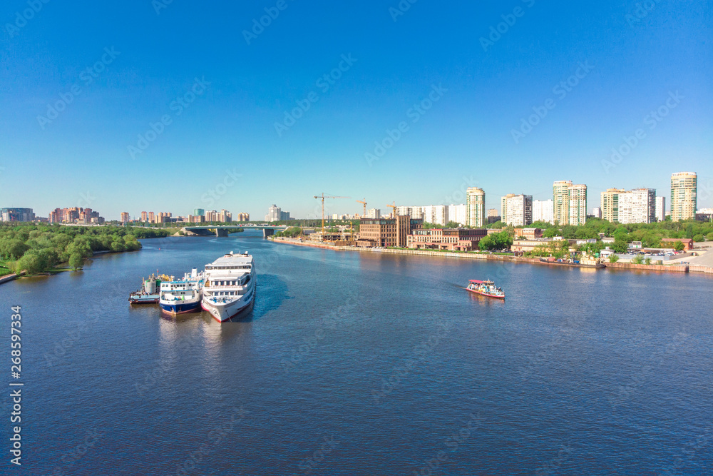 Scenic view of the city by the river with ships sailing on it. Concept clean city, life in the city. aerial shot, top shot