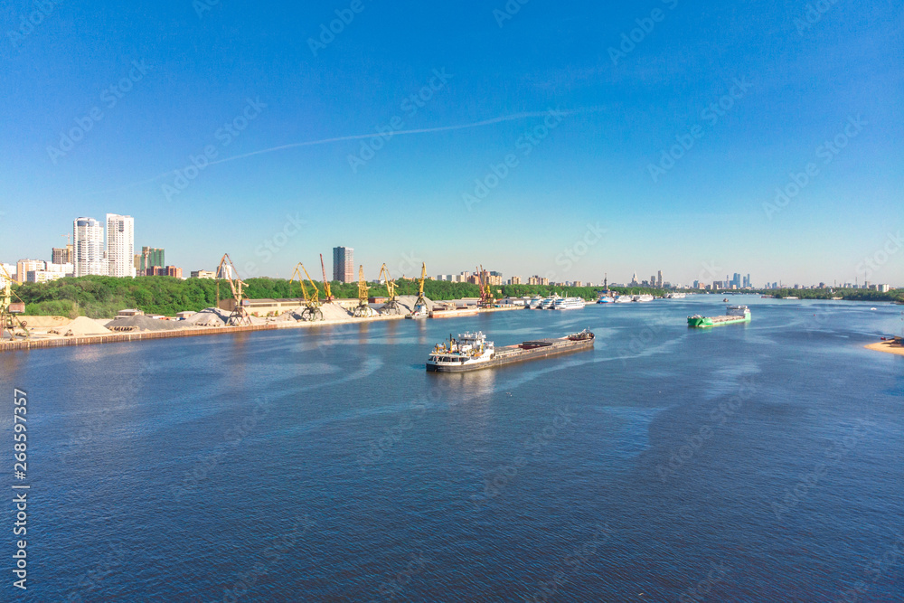 Naklejka premium Scenic view of the city by the river with ships sailing on it. Concept clean city, life in the city. aerial shot, top shot