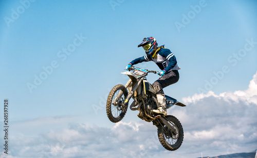 A picture of a biker making a stunt and jumps in the air