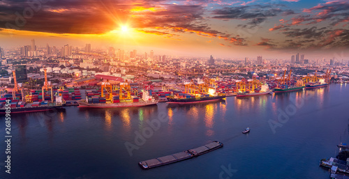 Logistics and transportation of Container Cargo ship and Cargo plane with working crane bridge in shipyard at sunrise, logistic import export and transport industry background © Travel mania