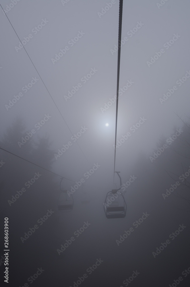 Mystical cableway leading in gray fog Mystical cableway leading in gray fog