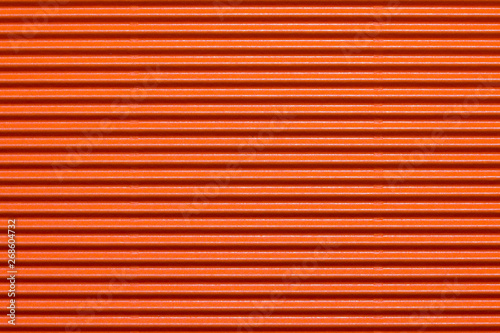 Abstract textured background created with striped details of orange corrugated cardboard