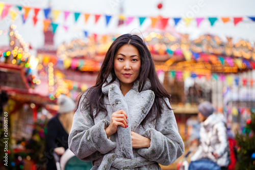 Happy asian woman in winter coat from faux fur