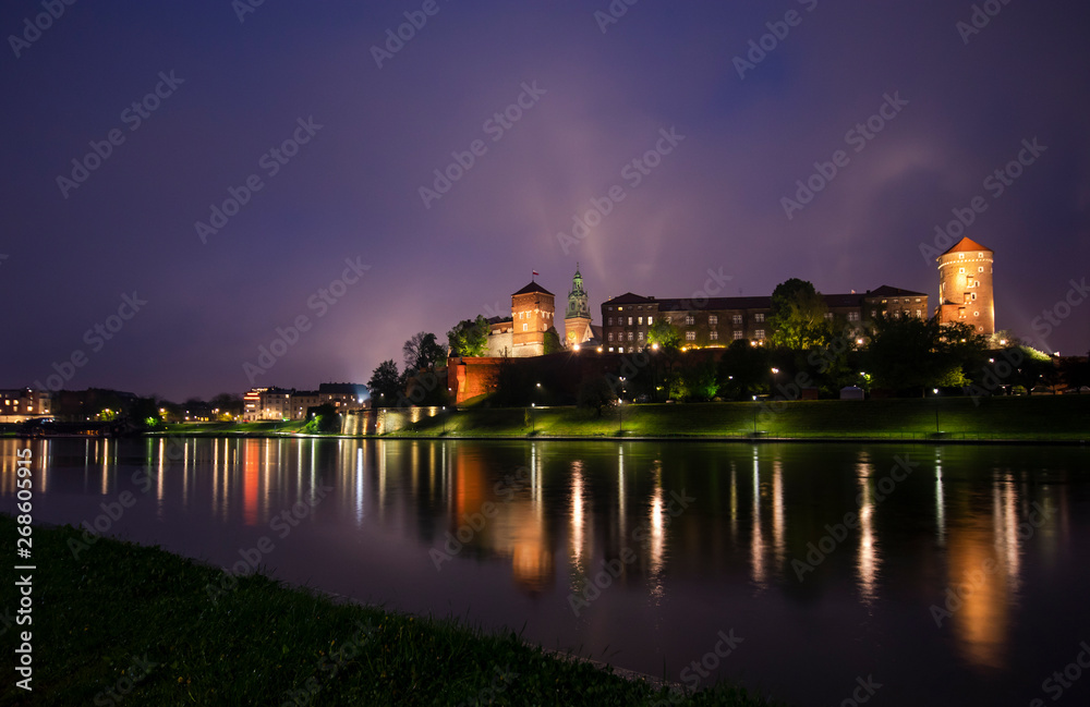 View of the night KRAKOW. The Royal Wawel Castle as seen from another bank of Vistula in Krakow, Poland, Europe