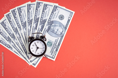 US dollars with clock on red background composition