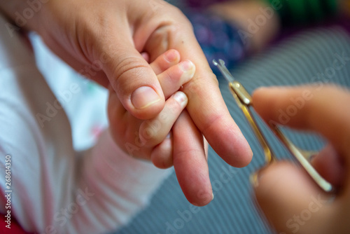 Mother is cutting nail.