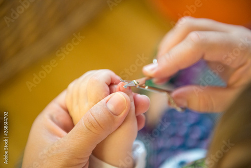 Mother is cutting nail.