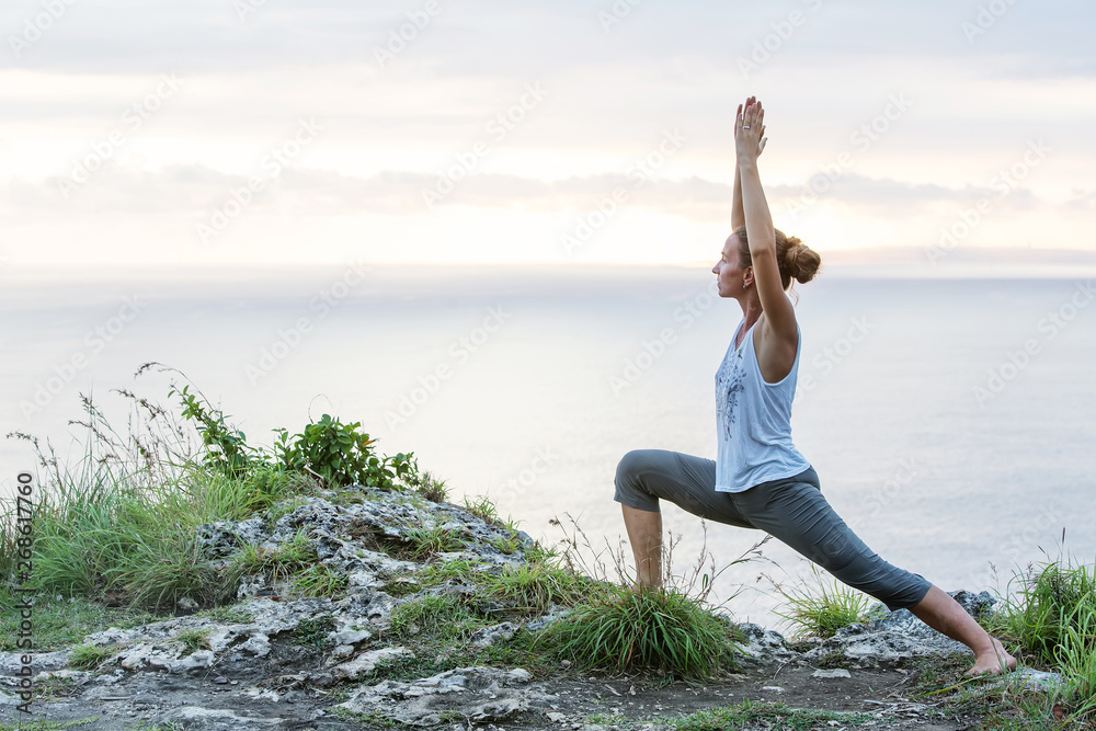 Caucasian woman practicing yoga at seashore Caucasian woman practicing yoga at seashore