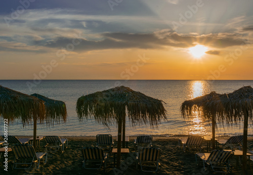 empty beach with thatched umbrellas and sun loungers in the mornings in summer