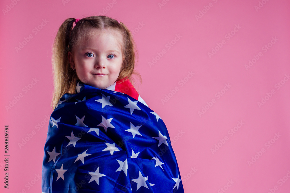 caucasian happy female baby in striped blue and white navy suit holding american flag in hand on a pink background in the studio.English language learning and freedom future profession army navy dream caucasian happy female baby in striped blue and white navy suit holding american flag in hand on a pink background in the studio.English language learning and freedom future profession army navy dream