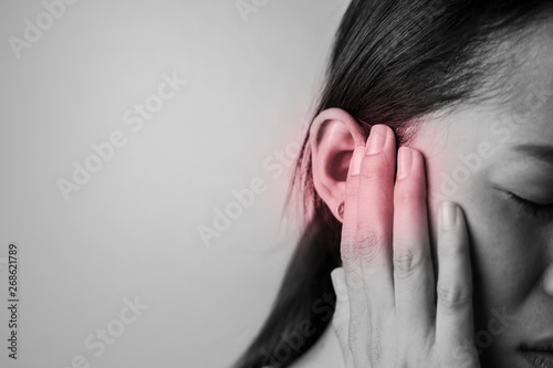 Young woman is suffering of earache.
