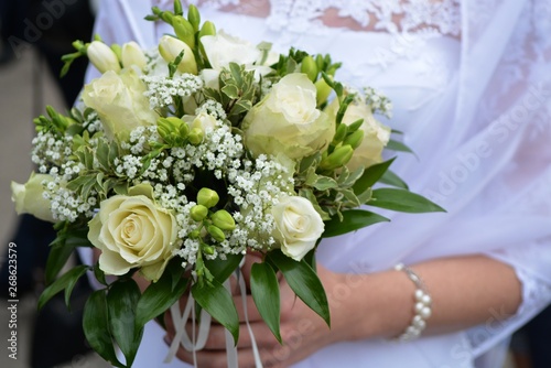 The bride is holding a bouquet of the bride from white roses