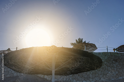 Thatched beach umbrella on a beach at an idyllic tropical resort for a summer vacation