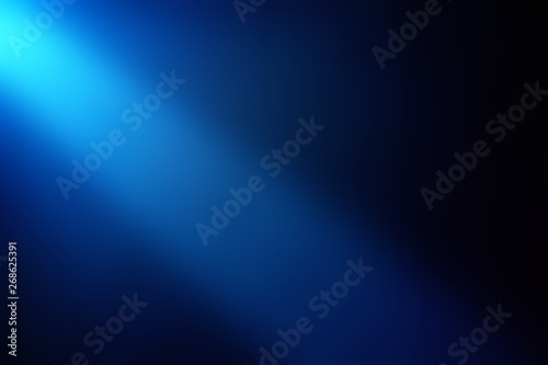 Dark blue beam of light shining from top to bottom on a dark background.