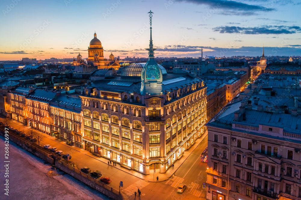 Naklejka premium ST. PETERSBURG, RUSSIA - MARCH, 2019: Department store shop class luxury, near the Red Bridge. In the background the city and St. Isaac's Cathedral, in the evening at sunset