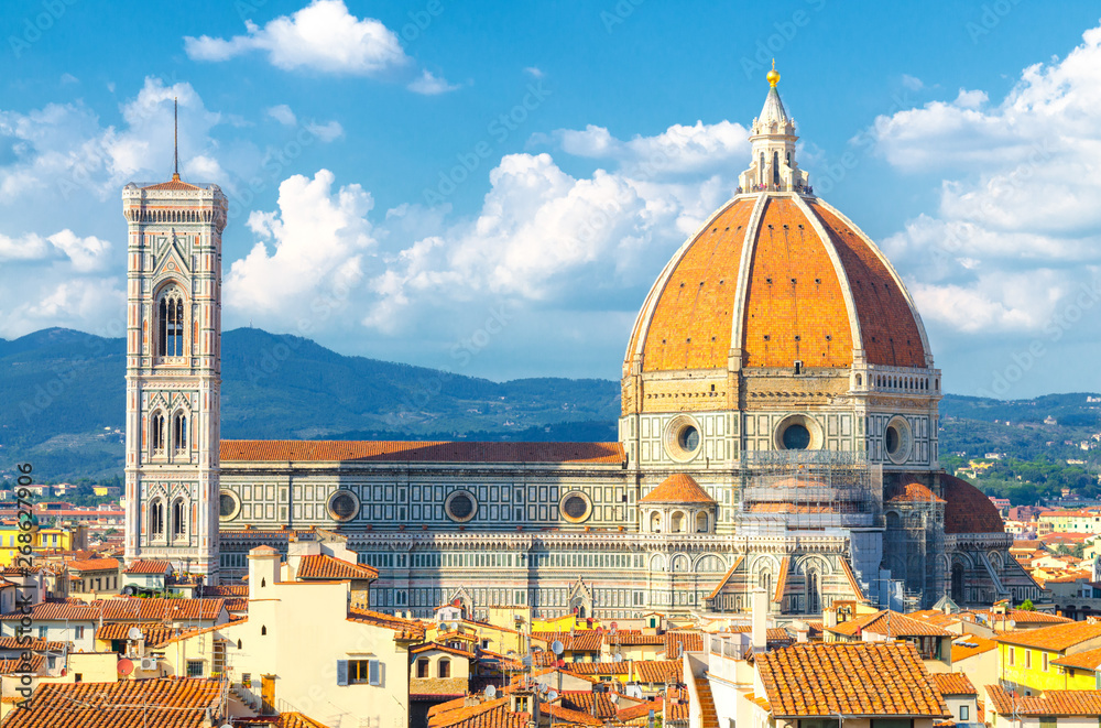 Top aerial panoramic view of Florence city with Duomo Cattedrale di Santa Maria del Fiore cathedral, buildings houses with orange red tiled roofs and blue sky white clouds, close up, Tuscany, Italy