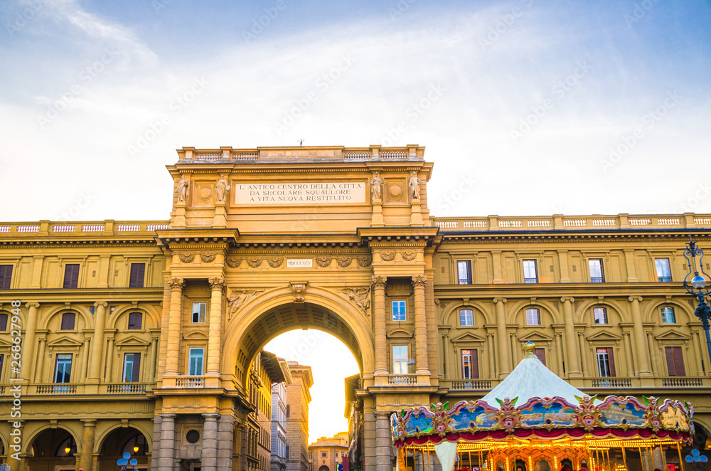 Obraz premium Arch between buildings and Vintage carousel on Piazza della Repubblica Republic square in historical centre of Florence city, blue sky white clouds, Tuscany, Italy