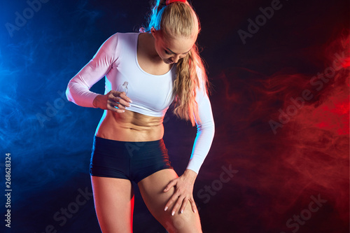 Fotografie blonde sportswoman touching soft fresh skin isolated on black background