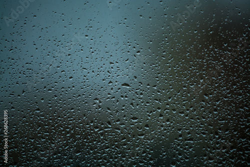 Background or texture. It is a lot of small a rain drops on window glass. Rainy day of spring.