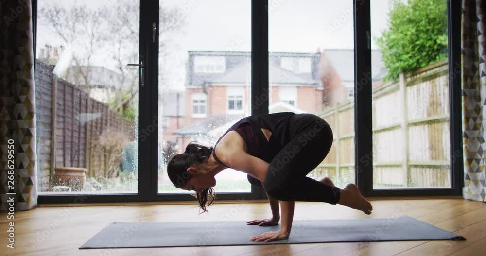 4K Young fit woman doing yoga practice, holding her balance in 'crow' pose. Slow motion. 4K Young fit woman doing yoga practice, holding her balance in 'crow' pose. Slow motion.