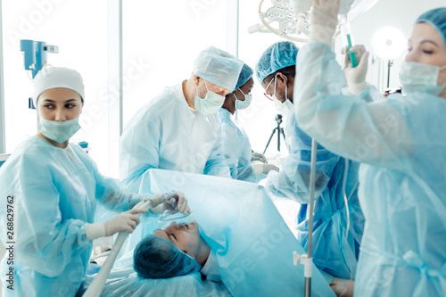 prbusy working day in the operating room. doctors rushing to help the patient