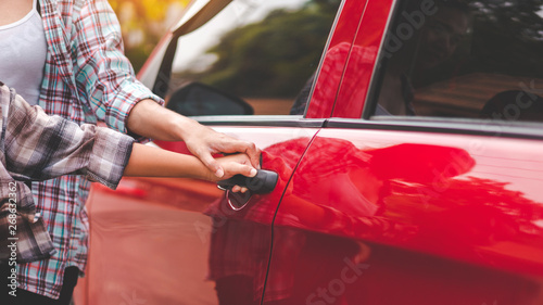 Close up hand of asian mother or parent helping son or pupil to getting in the red car to ride to school, Back to school concept, Selective focus.