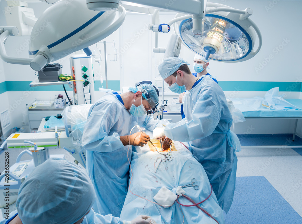 Spinal surgery. Group of surgeons in operating room with surgery equipment. Laminectomy Spinal surgery. Group of surgeons in operating room with surgery equipment. Laminectomy