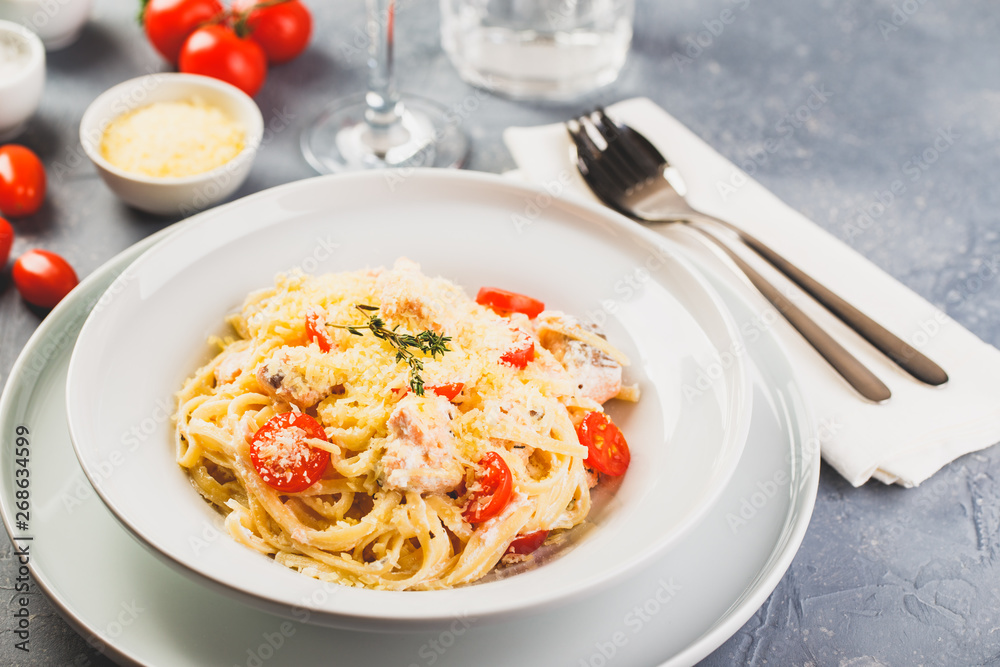 Delicious salmon linguine pasta dish with herbs and grilled salmon filet. Delicious salmon linguine pasta dish with herbs and grilled salmon filet.