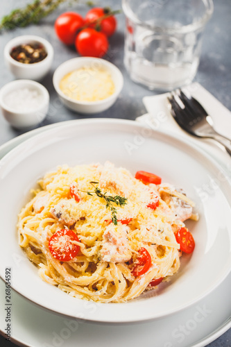 Delicious salmon linguine pasta dish with herbs and grilled salmon filet.