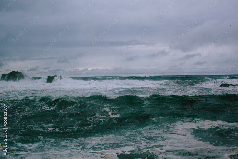 Waves of a raging dark sea crashing on rocks