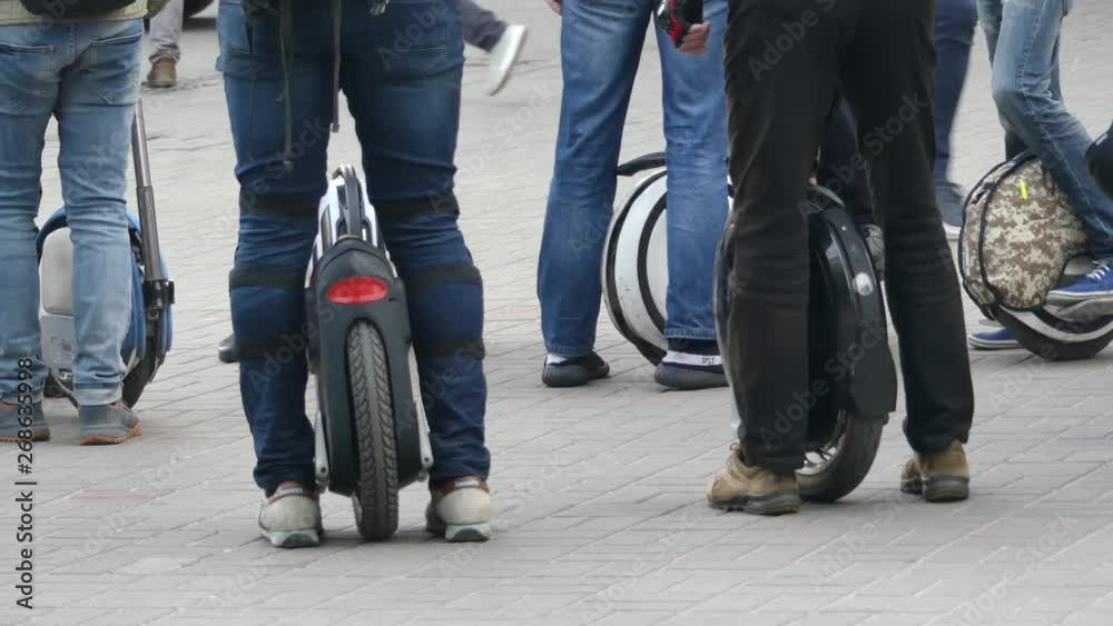 Personal electric transport, monowheel. Close-up, many legs on monowheels. Collection of electric transport lovers. Personal electric transport, monowheel. Close-up, many legs on monowheels. Collection of electric transport lovers.