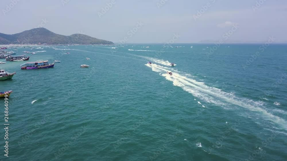 Forward motion low drone shot entering a party island resort filled with tour boats and tourist traffic - Forward moving aerial footage coming into a popular busy tourism exotic island destination 4k Forward motion low drone shot entering a party island resort filled with tour boats and tourist traffic - Forward moving aerial footage coming into a popular busy tourism exotic island destination 4k