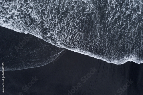 Aerial drone shoot from above black sand beach. Nature texture