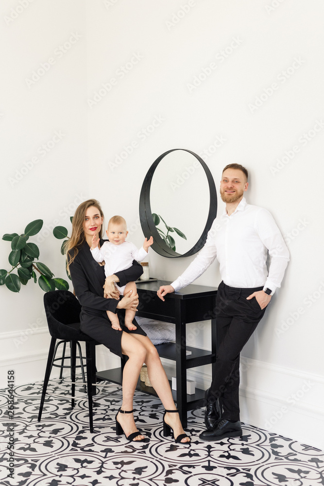 Obraz premium young beautiful family stylishly dressed standing in a bright apartment