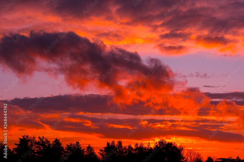 Fiery orange sunset  colorful and speckled  clouds.