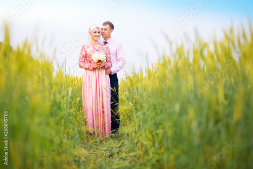 Smiling young islamic couple portrait on sunflowers field photo