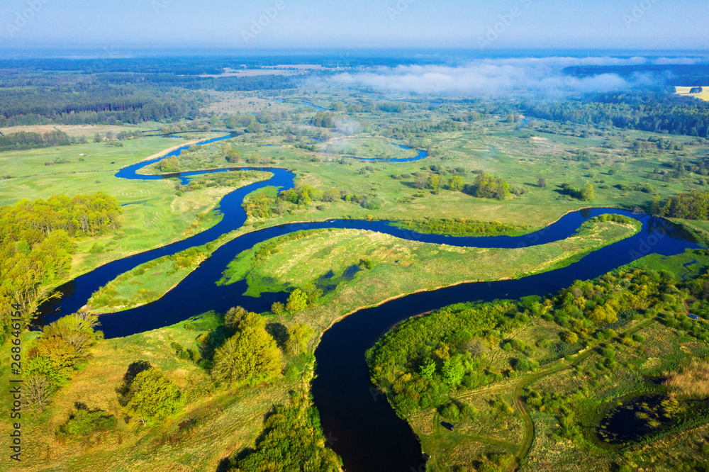 Summer nature landscape from above. River aerial view. Green meadow on riverside in the morning. Spring background