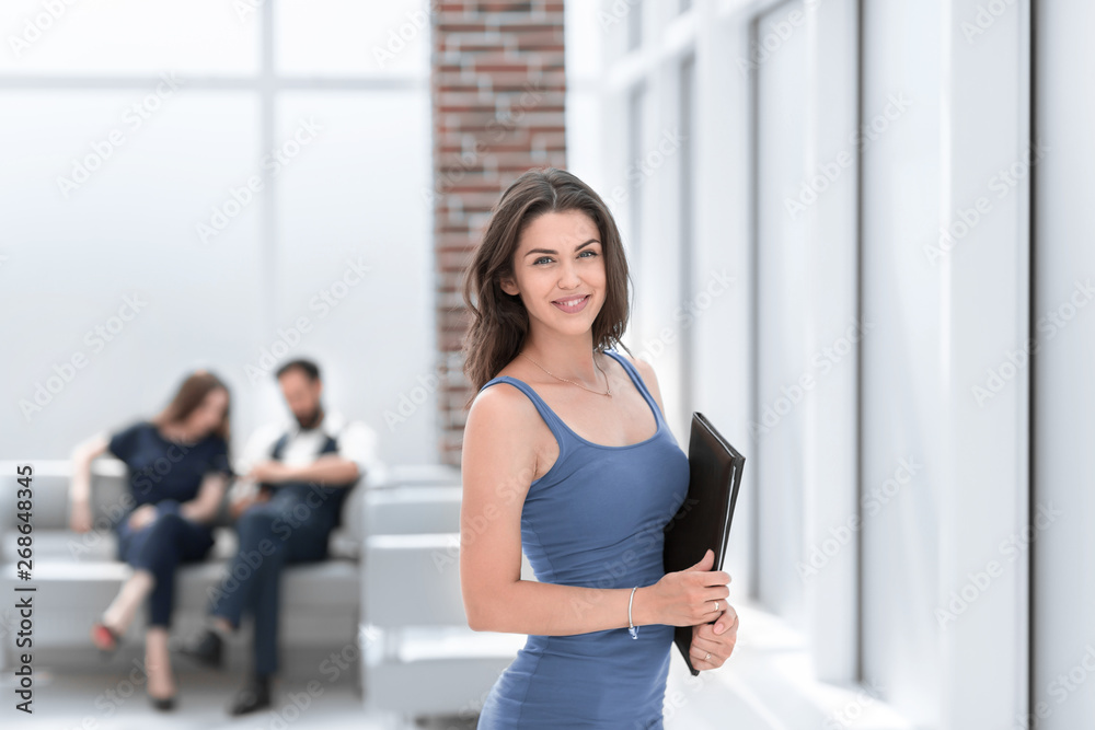young business woman with clipboard standing in office lobby