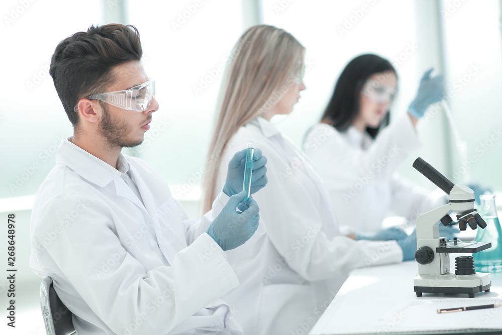 group of young biologists sitting at the laboratory table group of young biologists sitting at the laboratory table
