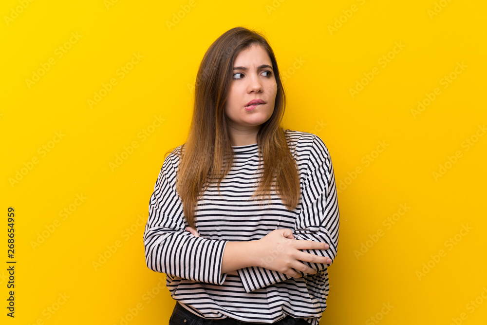 Young girl over yellow wall with confuse face expression Young girl over yellow wall with confuse face expression