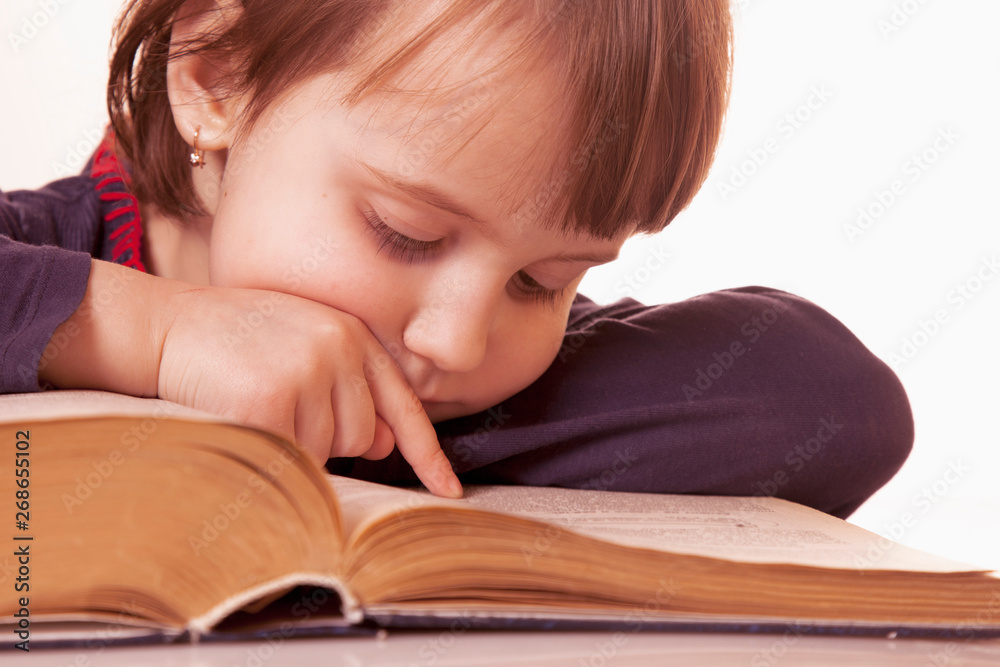 Little cute child girl watching a book as symbol of education and knowledge Little cute child girl watching a book as symbol of education and knowledge