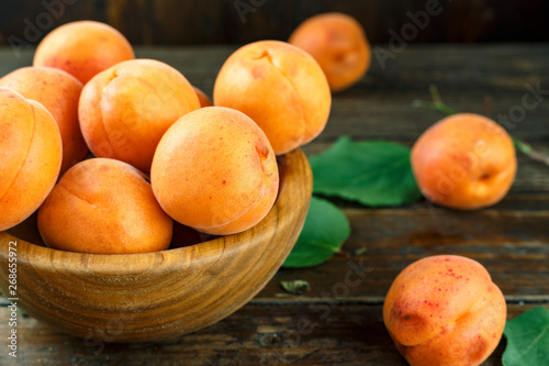ripe apricots in a wooden plate