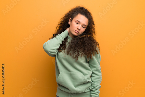 Teenager girl over ocher wall with neckache © luismolinero